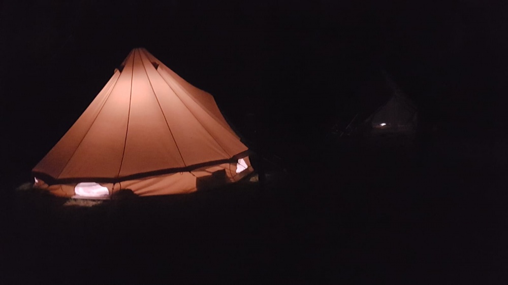 Tenda indiana di campus Sesia Rafting illuminata nella notte.