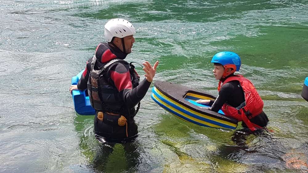 Guida di hydrospeed spiega ad un bambino del Campus come affrontare una rapida.