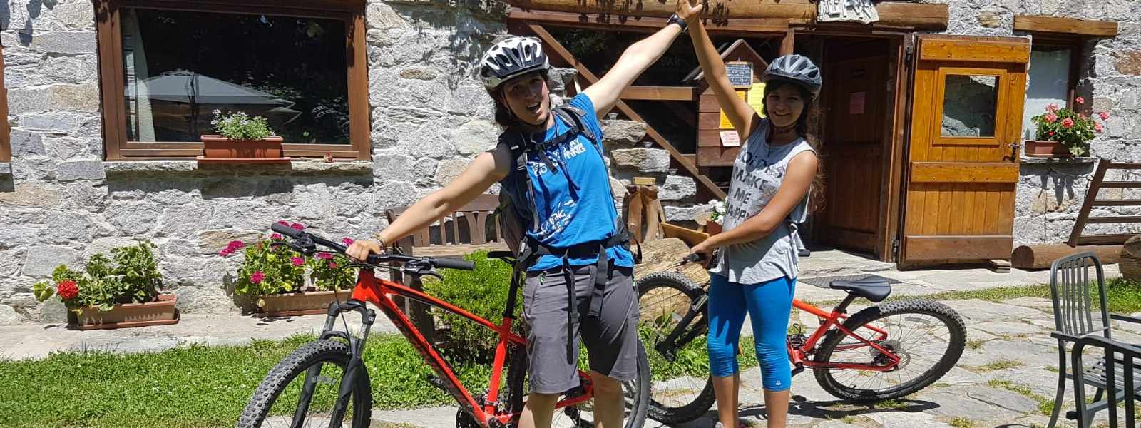 Guida e allieva lungo la discesa della pista ciclabile di Alagna Valsesia